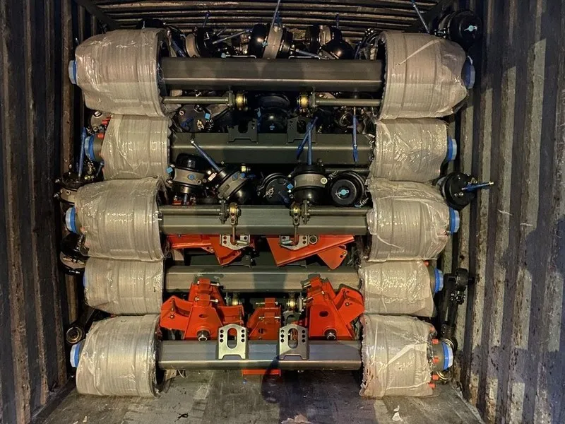 Trailer axles and suspension parts loaded in layers inside a shipping container