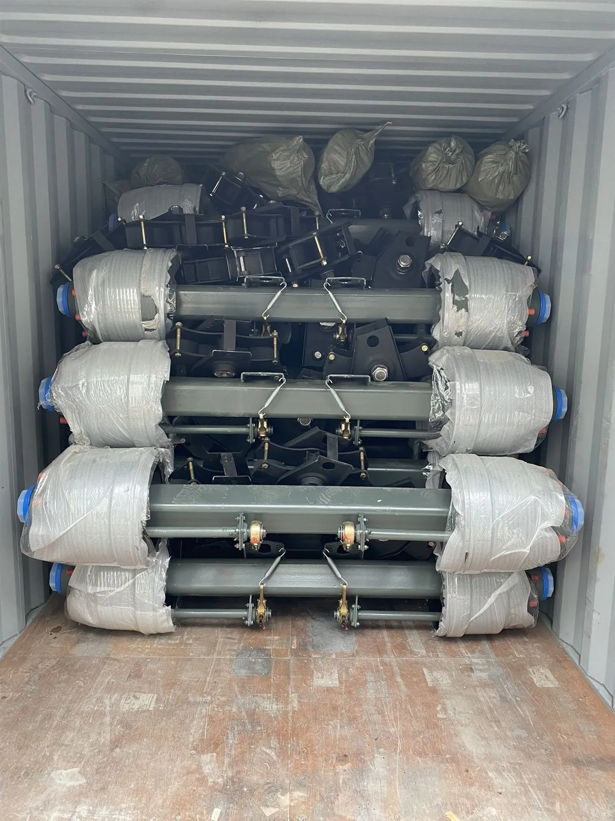 Suspension axle assemblies wrapped and packed inside a shipping container