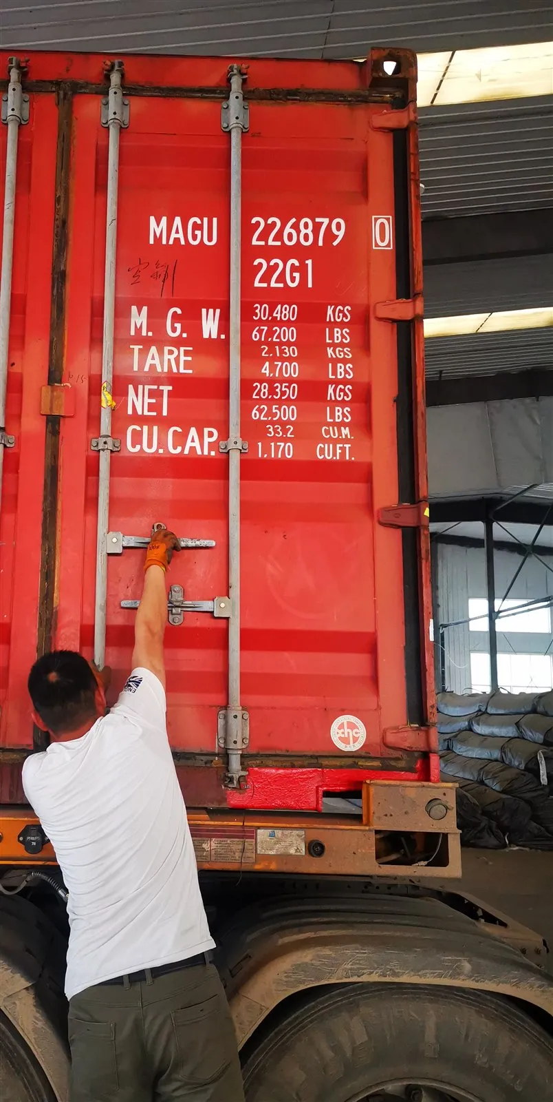 Container doors being locked and sealed after loading, container number visible